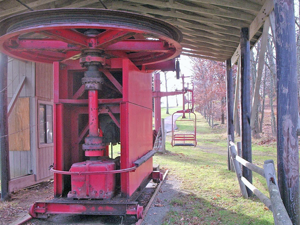 This shows some of the classic Hall chairlift features like the bullwheel and drive mounted on rails (like a railcar), and the separate cross arms on the lift towers fastened together making a lower case 